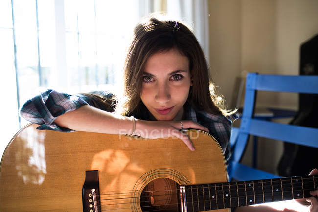 Портрет улыбающейся девушки с гитарой — стоковое фото