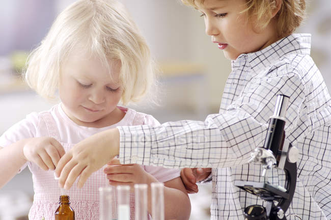 Двох маленьких дітей, що грають з посудом хімічної лабораторії — стокове фото