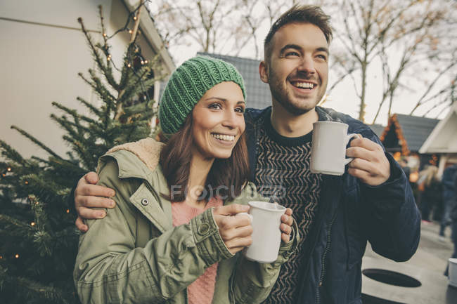 Couple having a hot punch on the Christmas Market — Stock Photo