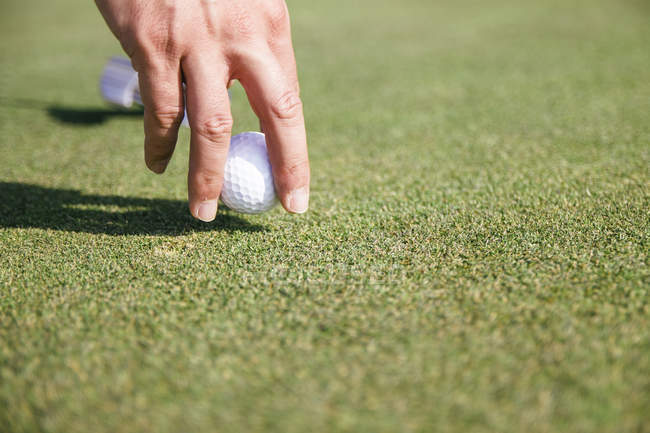 Primo piano di una mano di un uomo che prende una pallina da golf — Foto stock