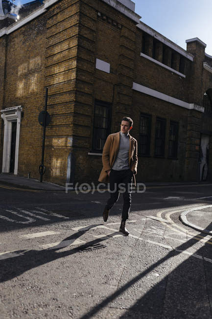 Junger Mann überquert Stadtstraße — Stockfoto