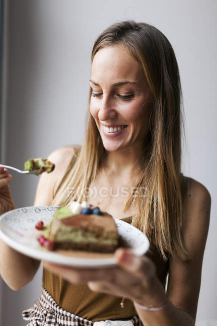 Woman eating vegan matcha cake — Stock Photo