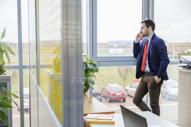 Молодой бизнесмен на телефоне в офисе — стоковое фото