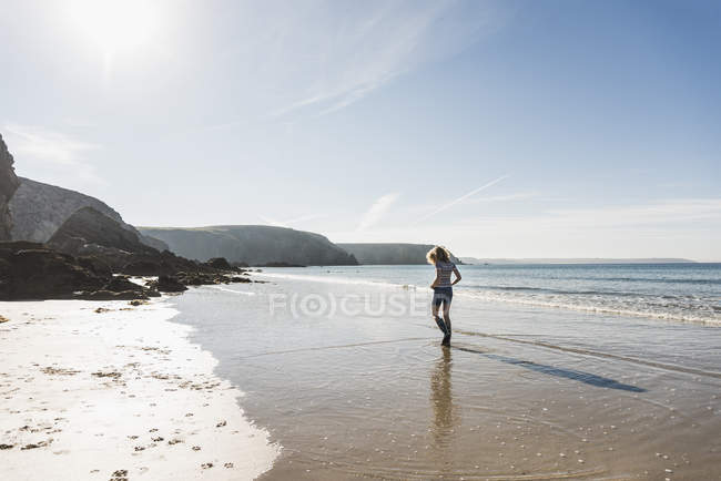 Teenage girl walking on sand beach — Stock Photo