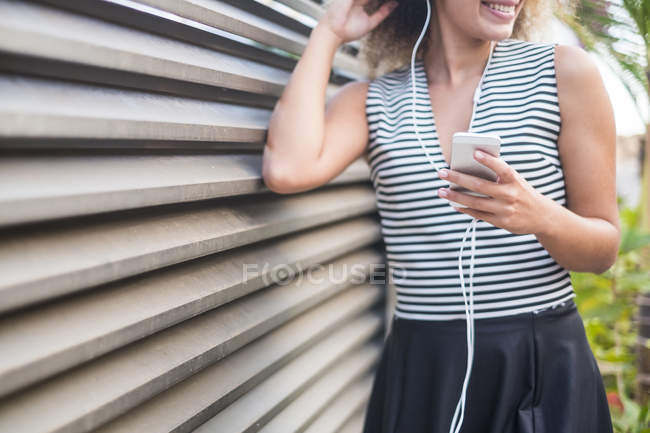 Mujer joven con smartphone escuchando música - foto de stock