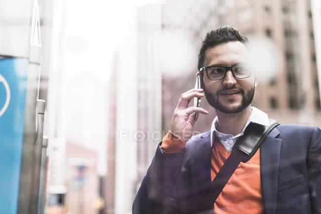 Confident businessman using smartphone in city — Stock Photo