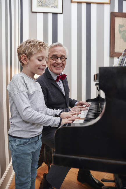 Nonno e nipote suonano il pianoforte insieme — Foto stock