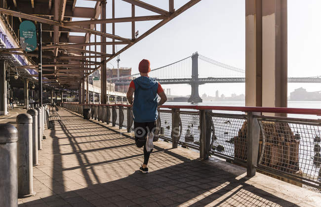 USA, New York City, man running at East River — Stock Photo