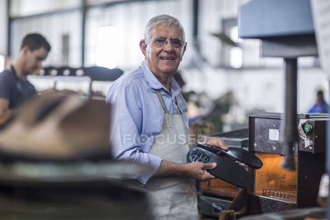 Сапожник-кузнец работает на обуви в мастерской — стоковое фото
