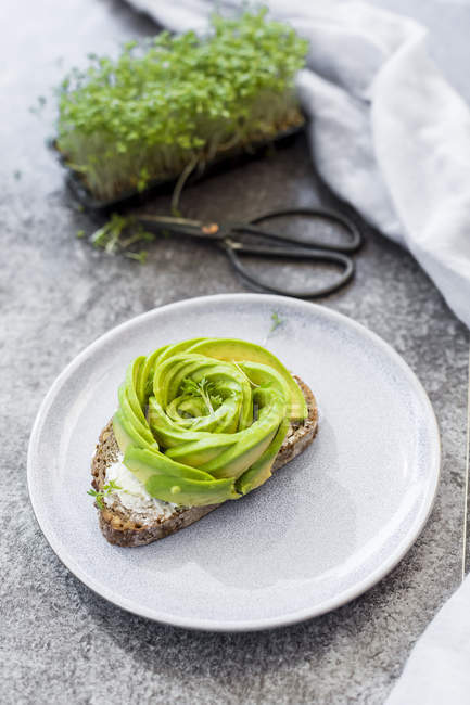 Avocado rose on bread, cress — Stock Photo