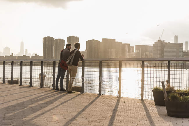 Двоє молодих людей говорити на Іст-Рівер, Нью-Йорк, США — стокове фото