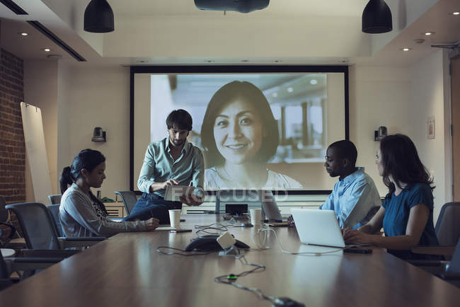 Gente de negocios que tiene una videoconferencia en la sala de juntas - foto de stock