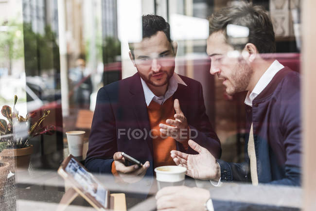 Geschäftsleute treffen sich im Café und nutzen mobile Geräte — Stockfoto