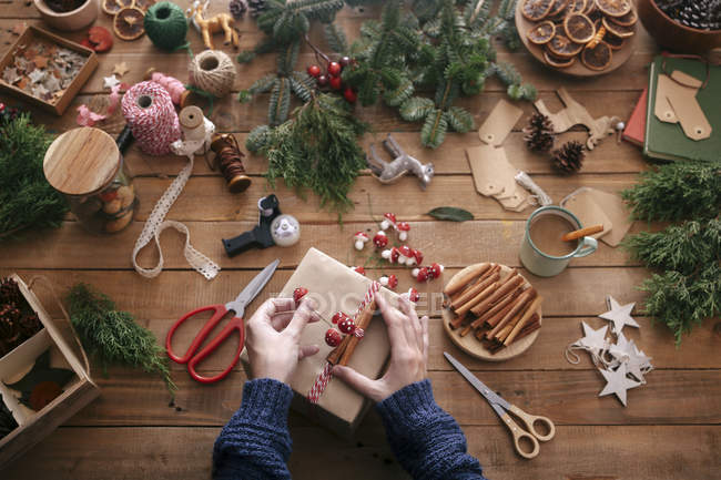 Woman's hands decorating Christmas present — Stock Photo