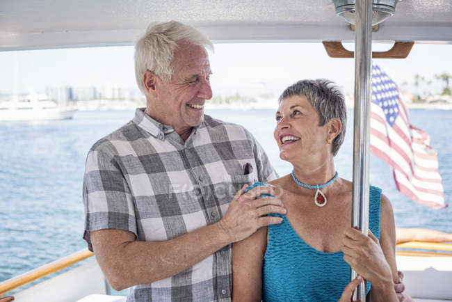 Coppia sorridente in gita in barca in piedi insieme e guardando la vista — Foto stock