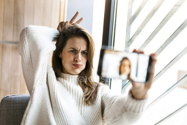 Jeune femme caucasienne attrayante prenant selfie à la maison — Photo de stock