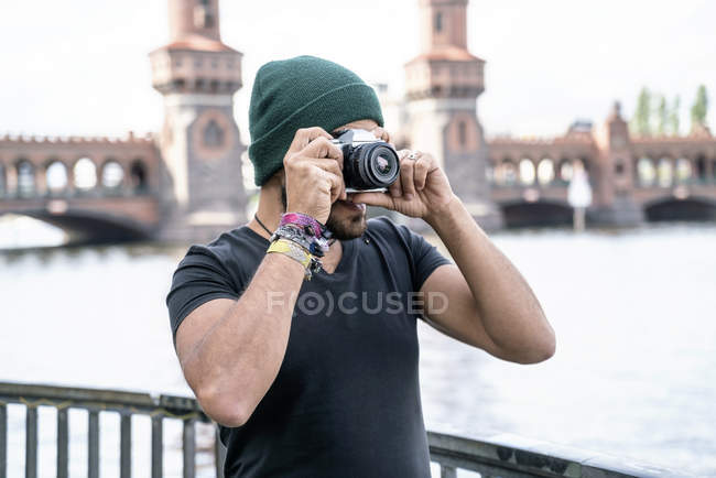 Alemania, Berlín, hombre tomando fotos con cámara delante del puente de Oberbaum - foto de stock