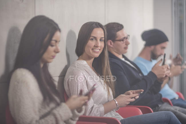 Portrait of smiling businesswoman waiting with colleagues — Stock Photo