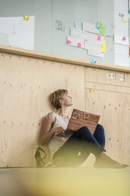 Femme d'affaires utilisant un ordinateur portable sur le sol — Photo de stock