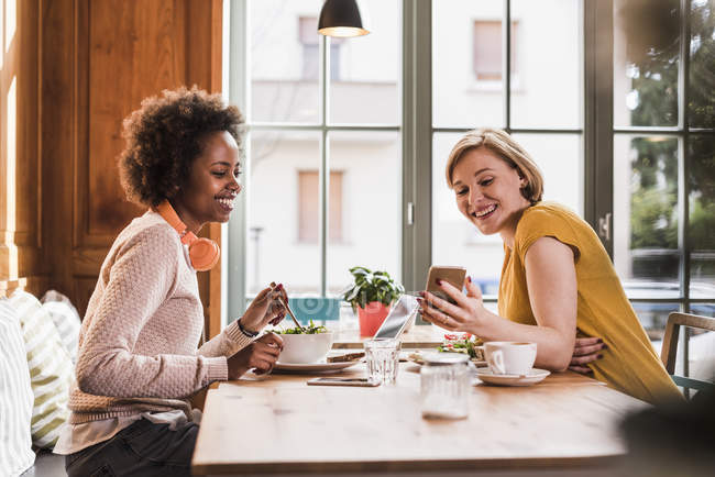 Two Young Women With Cell Phone Meeting In A Cafe Technology Joy Stock Photo 177770482