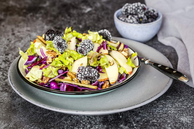 Bowl of salad with lettuce, red cabbage, blackberries, apple and walnuts — Stock Photo