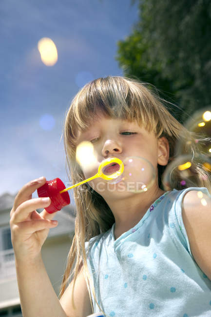 Ritratto di bambina che soffia bolle di sapone — Foto stock