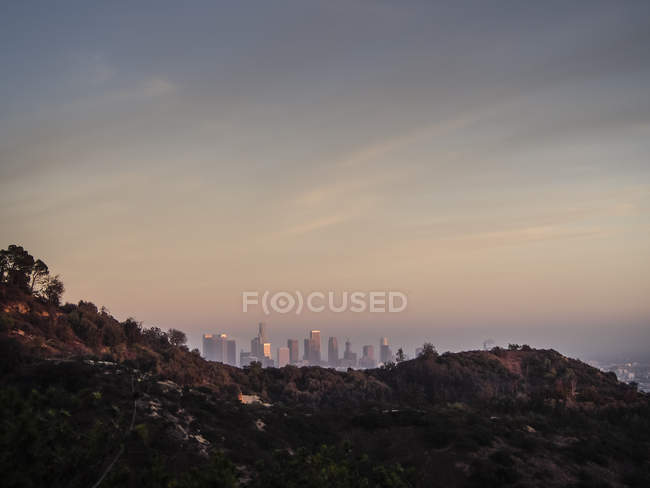 Vista distante da cidade de Los Angeles horizonte ao pôr do sol — Fotografia de Stock