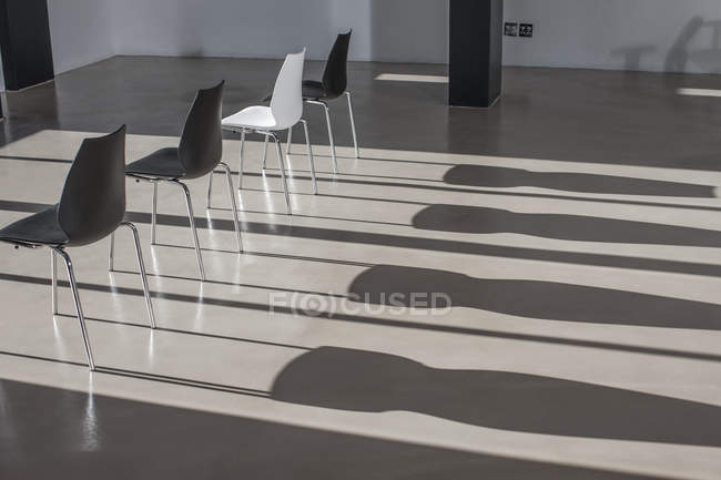 Fila di sedie in ombre di colata ufficio vuote — Foto stock