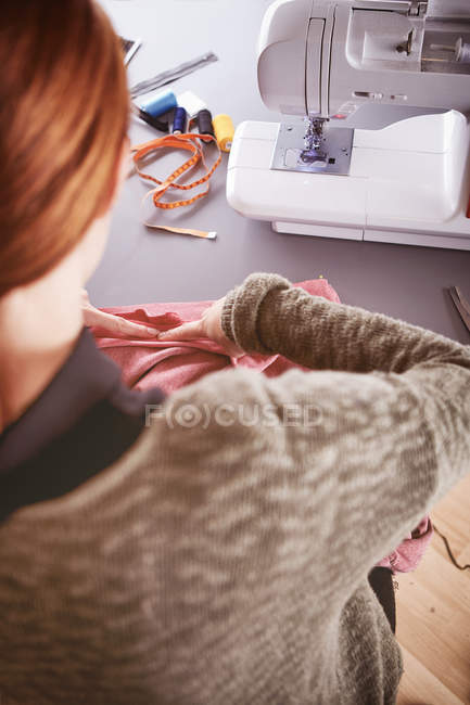 Vista posteriore di giovane donna con macchina da cucire a casa — Foto stock