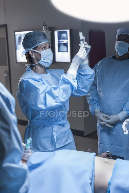 Arzt bereitet Spritze für Patientin im OP vor — Stockfoto