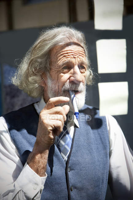 Senior professor writing on adhesive notes — Stock Photo