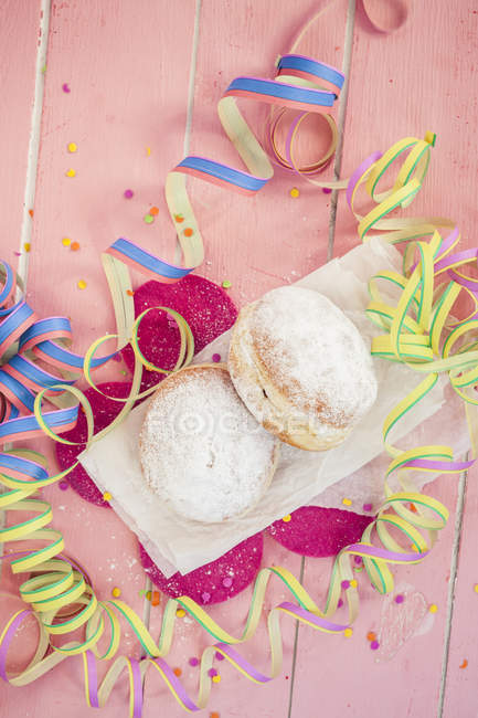 Top view of Berliner doughnuts on paper and streamers — Stock Photo