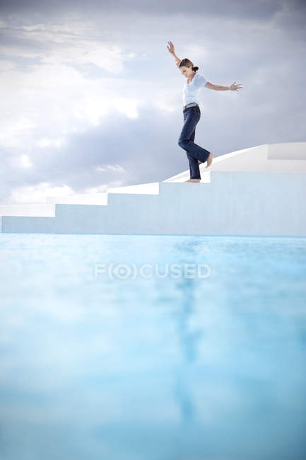 Espanha, Maiorca, mulher balanceando nas escadas com ao lado de uma piscina — Fotografia de Stock