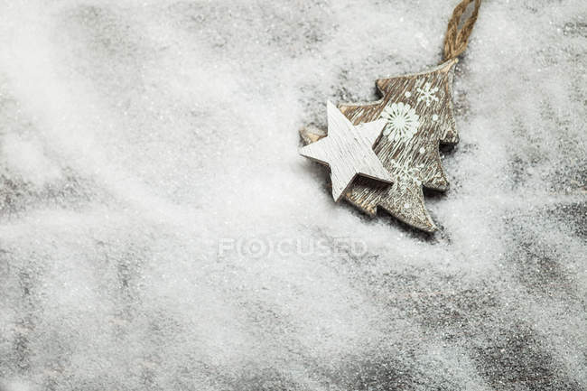 Vista ravvicinata di stella di legno e albero di Natale in neve artificiale — Foto stock