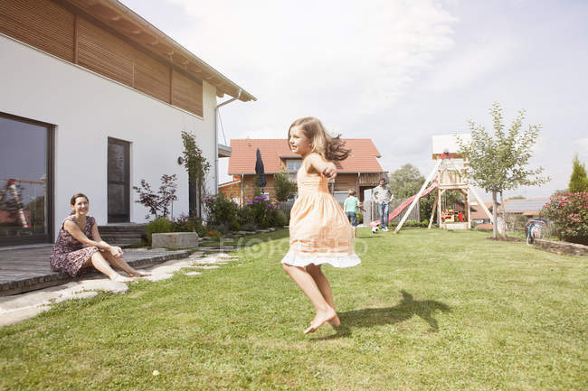 Giocoso caucasico ragazza con la famiglia in giardino — Foto stock