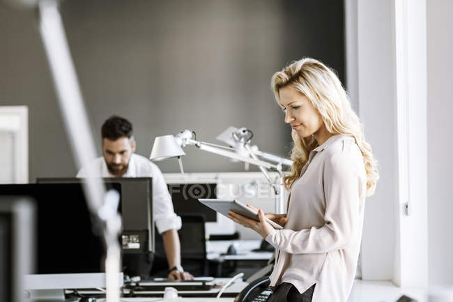 Zwei Kollegen im Büro mit digitalem Tablet und Computer — Stockfoto