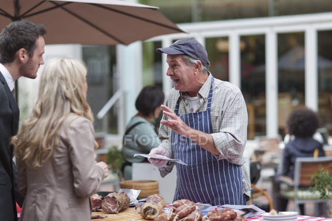 Man selling sausages at city market — Stock Photo