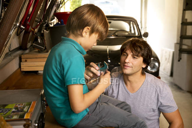 Father And Son In Garage With Vintage Car And Tools Two