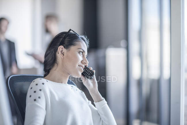 Donna in ufficio che parla al telefono — Foto stock