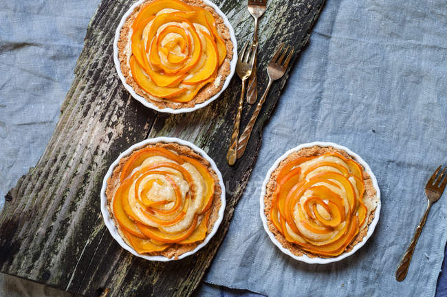 Closeup view of three almond pies with kaki slices — Stock Photo
