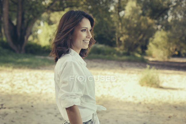 Retrato de mujer sonriente mirando a la distancia - foto de stock