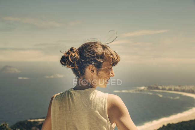 Brazil, Woman looking down onto Copacabana of Rio de Janeiro from Sugarloaf Mountain — Stock Photo