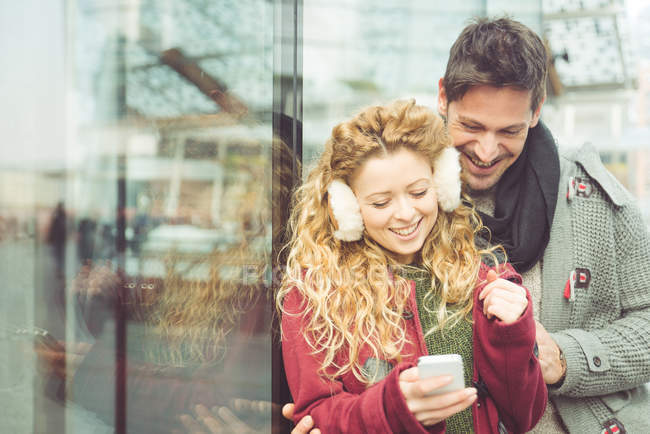 Happy couple looking at smartphone — Stock Photo