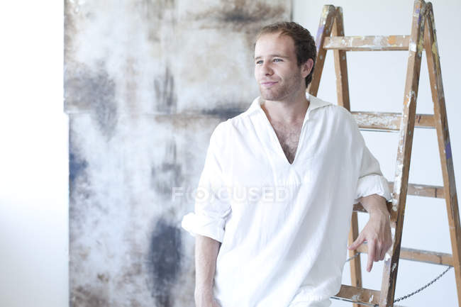 Ritratto di giovane pittore sorridente nel suo studio — Foto stock