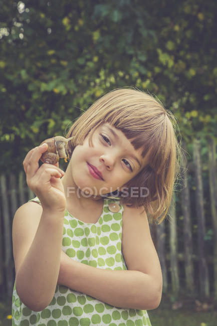 Porträt eines lächelnden kleinen Mädchens mit Weinbergschnecke — Stockfoto