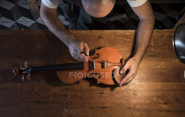 Luthier regola il post sonoro di un violino nel suo laboratorio — Foto stock