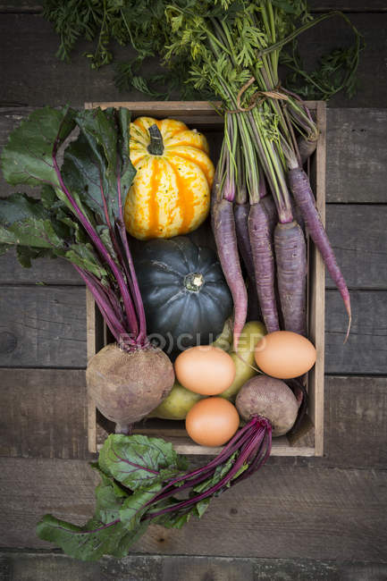 Boîte en bois de différents légumes biologiques — Photo de stock