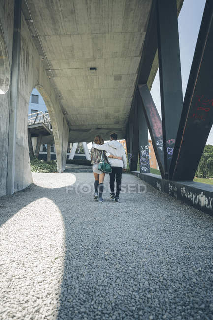 Вид ззаду молодої пари в любові рука ходьби в руці — стокове фото