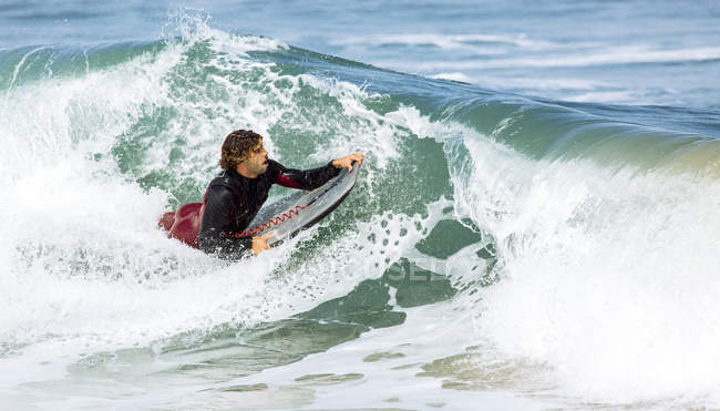 Surfista sdraiato sulle onde in mare — Foto stock