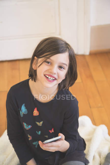 Retrato de menina sorridente segurando smartphone — Fotografia de Stock
